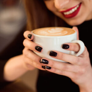 Smiling woman in a good mood enjoy cup of coffee sitting in cafe.